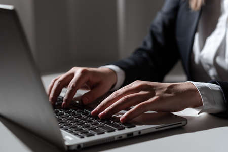 Businesswoman Typing Recent Updates On Lap Top Keyboard On Desk. Woman In Office Writing Important...