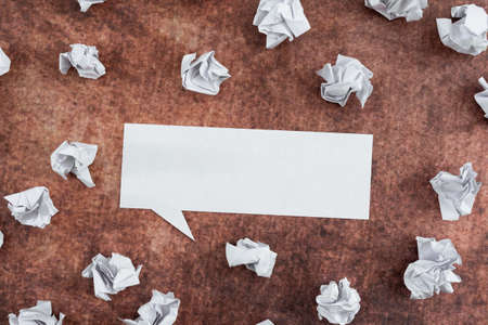 Speech Bubble Made Of Sheet Surrounded With Crumpled Papers Over Wooden Background. It Is Showing Different Thoughts And Analyzing Strategies For Business.の写真素材