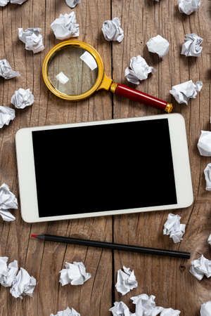Tablet With Important Information With Paper Wraps, Pencil And Magnifier Around. Phone Screen With Crutial Message With Crumpled Notes All Over And Crayon.の写真素材