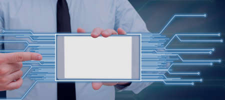 Businessman Holding A Cellphone And Pointing On The Screen With Glowing Lines In A Creative Frame....