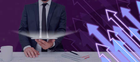 Businessman Holding A Tablet In A Futuristic Design With Arrows Going Up. Man In Suit Showing...