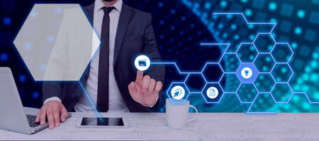 Businessman With A Laptop And A Tablet With Hand Pointing On A Pattern With Symbols Presenting...