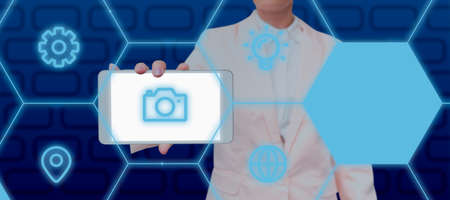 Businesswoman Showing Smartphone With Digitally Generated Multiple S And Hexagon Pattern. Elegant Woman With Cellphone Presenting Important Business Information.の写真素材