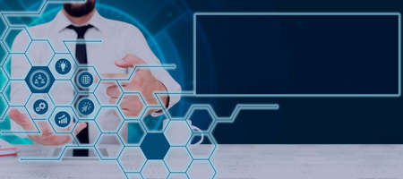 Businessman With A Touch Screen Displaying Digital Symbols In A Glowing Hexagon Pattern. Man In A...