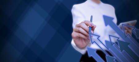 Lady in suit holding pen symbolizing successful teamwork accomplishing newest project plans. Woman carrying ballpoint pencil representing combined effort management.の写真素材