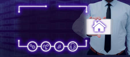 Businessman Showing Smartphone With House By Digital Generated Frame And Multiple Symbols. Man...
