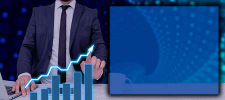 Businessman With Laptop And Pointing With Two Fingers Data On Graphs In Abstract Design. Man In Suit Showing Chart Presentations And Important Data In A Meeting.の写真素材