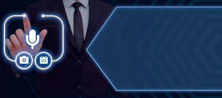 Businessman Pointing On The Mic Symbol And A Digital Display Of Glowing S With Futuristic Design....