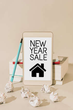 Writing displaying text New Year Sale. Business showcase Final holiday season discounts price reductions Offers Important Messages Presented On Mobile Phone Leaning On Books And Notebook.