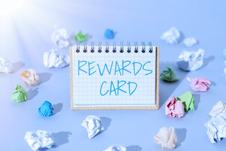 Hand writing sign Rewards Card. Concept meaning Help earn cash points miles from everyday purchase Incentives Important Message Presented On Notepad With Paperwraps All Aroud.の写真素材