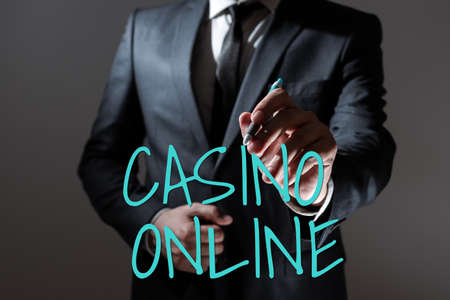Conceptual caption Casino Online. Business approach Computer Poker Game Gamble Royal Bet Lotto High Stakes Businessman Holding Pen And Presenting Important Informations.の写真素材