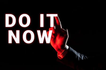 Writing displaying text Do It Now. Word for Respond Immediately Something needs to be done right away Businessman Pointing Important Infortmations With One Finger.の写真素材