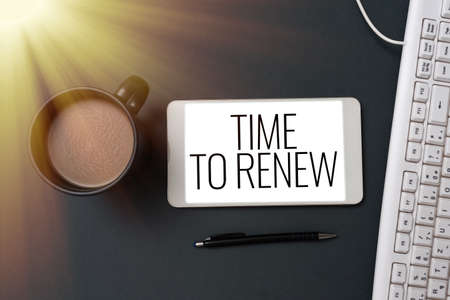 Conceptual display Time To Renew. Concept meaning Continue the insurance acquired Life and property protection Phone Screen With Important Message On Desk With Keyboard, Pen And Coffee.の写真素材