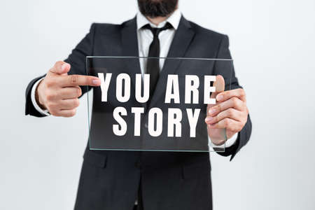 Writing displaying text You Are Story. Business showcase Your stories count and are important worth to tell everybody Businessman Holding Transparent Glass And Promoting The Company Brand.の写真素材