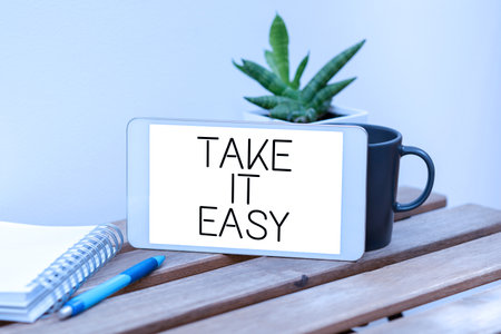 Inspiration showing sign Take It Easy. Conceptual photo Be relaxed do not worry about things stay calmed and rest Speech Bubble With Important Announcement Placed On Table With Coffee.の写真素材