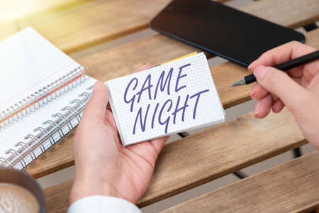 Conceptual caption Game Night. Business overview event in which folks get together for the purpose of getting laid Businesswoman Holding Pen And Notepad With Important Message.の写真素材