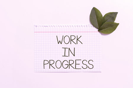 Conceptual caption Work In Progress. Business showcase Job still being done developing project business strategy Notebook Paper With Leaves Decorated For Promoting The Brand.の写真素材