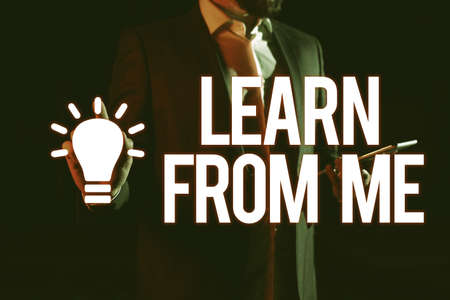 Hand writing sign Learn From Me. Business approach Follow my lead and examples Being a mentor for someone else Man Holding Tablet And Pointing With One Finger On Important Messageの写真素材