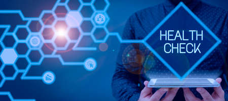 Conceptual caption Health Check. Conceptual photo Medical Examination Wellness and general state Inspection Businessman Holding A Pad Showing On Digital Symbols In A Hexagon Pattern.の写真素材