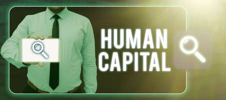 Hand writing sign Human Capital. Conceptual photo Intangible Collective Resources Competence Capital Education Man In Digital Frame Showing Cellphone With Searching Symbol On Screen.の写真素材
