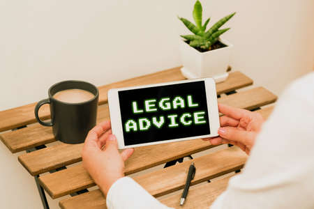 Writing displaying text Legal Advice. Internet Concept Lawyer opinion about law procedure in a particular situation Woman Holding Tablet With Recent Data On Table With Coffee, Pen And Plantの写真素材