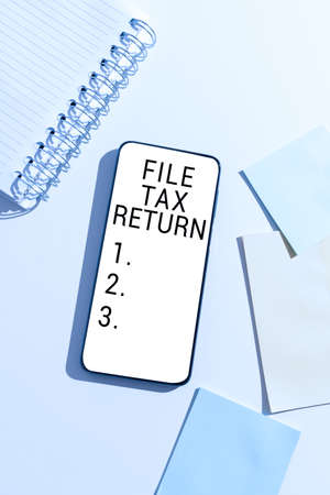 Conceptual caption File Tax Return. Business approach Paperwork to get financial money returning accountant job Mobile Phone With Important Message On Desk With Empty Notebook And Notes.の写真素材
