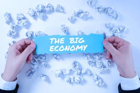 Text showing inspiration The Big Economy. Business approach Global finances Worldwide Market Trade Money exchange Man Holding A Pen And Pressing On Power Receiving Crucial Data.の写真素材