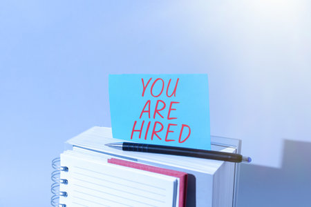 Hand writing sign You Are Hired. Business concept Recruitment being selected for a job the right candidateの写真素材