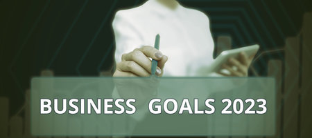 Conceptual display Business Goals 2023. Conceptual photo Setting Higher Standards Aim for the Impossible Businessman in suit holding tablet symbolizing successful teamwork.の写真素材
