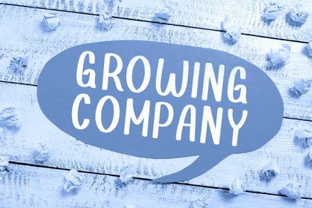 Hand writing sign Growing Company. Word Written on a business firm that is still undergoing a development Speech Bubble With Important Information Placed In Front Of Net.の写真素材