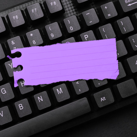 Colored sticker lying on black keyboard. Important information written over paper. Image with school...