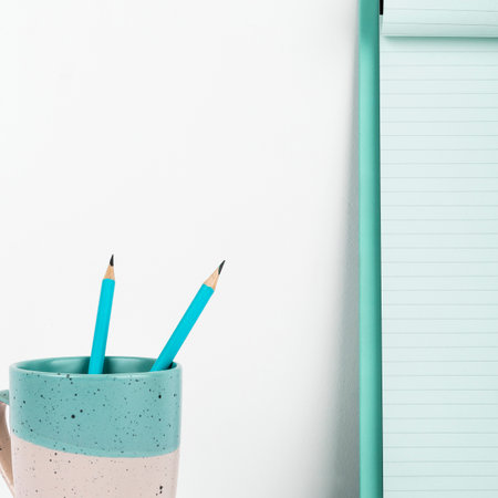 Coffee Cup Standing on Desk. Important infrormation written on paper. Different Office Supplies,...