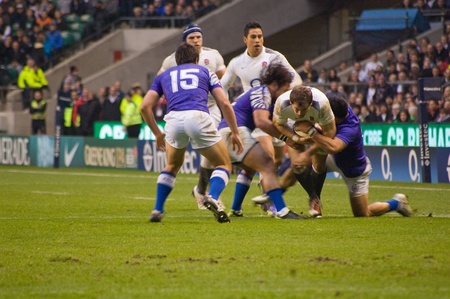 TWICKENHAM LONDON - NOVEMBER 20: English Player Tackled at England vs Samoa, England playing in white Win 26-13, at Investec Rugby Match on November 20, 2010 in Twickenham, Englandのeditorial素材