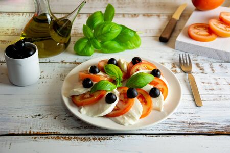 healthy summer salad made with organic Spanish tomatoes and low calorie mozzarella served with fresh basilの写真素材