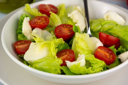 Salad with tomato cheese and lettuce, dietetic food, seasoned with Spanish olive oilの写真素材