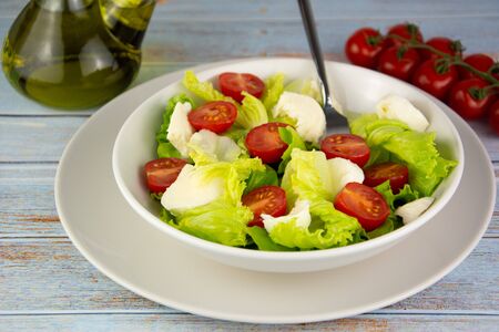 Salad with tomato cheese and lettuce, dietetic food, seasoned with Spanish olive oilの写真素材