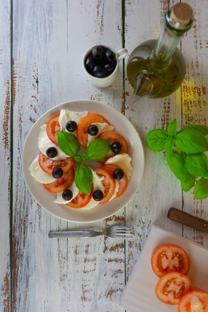 healthy summer salad made with organic Spanish tomatoes and low calorie mozzarella served with fresh basilの写真素材