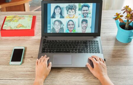 Woman teacher having a video call with multiracial students during isolation quarantine - Group of people chatting online - Technology and friendship concept - Focus on handsの写真素材