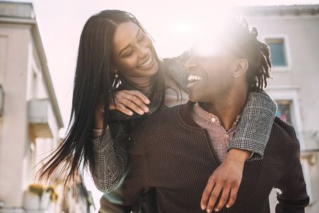 African couple having fun outdoor in city tour - Young people lovers enjoying time together during vacation journey - Love, fashion, travel and relationship concept - Focus on facesの写真素材