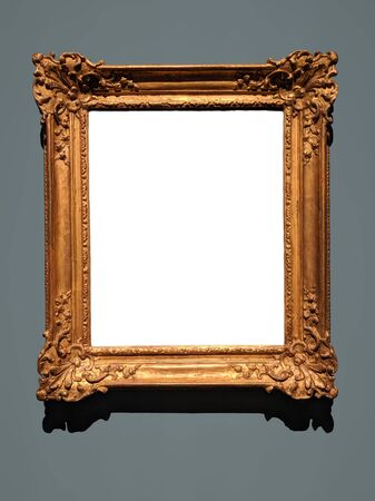 Blank canvas inside an elaborate golden wooden frame on a gray wall. Shadow on top of white canvas and below the frame matches the lighting.の写真素材