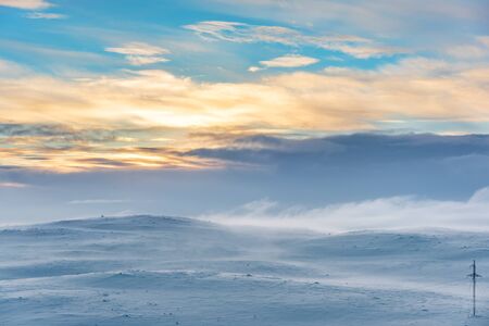 Snow Covered Arctic landscape with power line pylon at the bottom right symbolizing how technology...