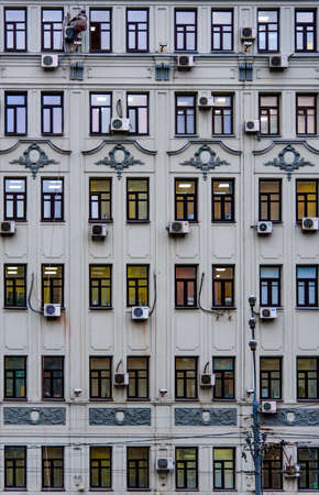 Moscow, Russia - 02 11 2016: A worker hangs in front of the top floor of a building facade while installing an air conditioning unit in the Russian Capitalのeditorial素材