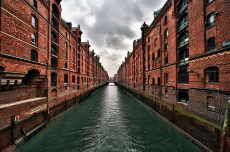 View of a canal in Hamburg famous old Speicherstadt warehouse district of brick buildings stand on timber-pile foundations in the port of Hamburg within the Hafen City quarterのeditorial素材