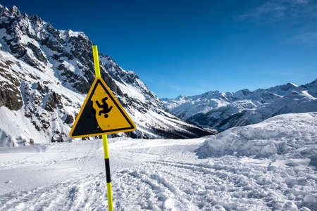Warning sign in the mountains warning of possible fallの写真素材
