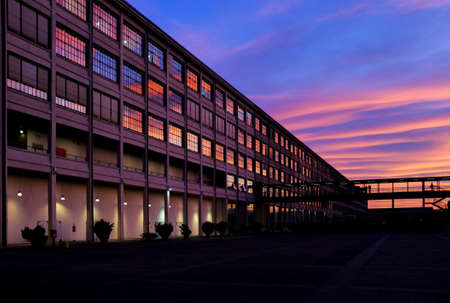 Turin, Italy - 01 21 2012: A spectacular sunset reflects on the large windows of a former industrial building (Lingotto)のeditorial素材