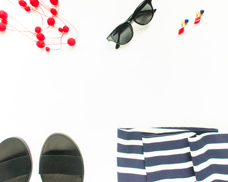 Summer fashion, summer outfit on white background. Blue striped dress, black sandals, black sunglasses, red necklace, vintage earrings. Flat lay, top viewの写真素材