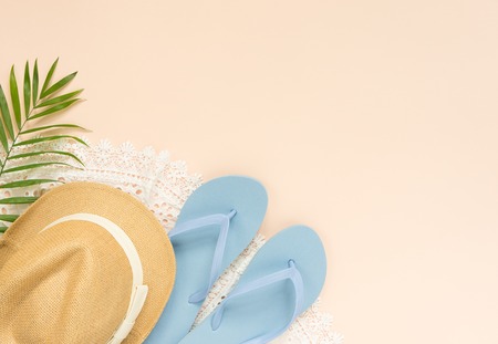 Summer fashion, summer outfit on cream background. White lace dress, blue flip flops and straw hat. Flat lay, top viewの写真素材