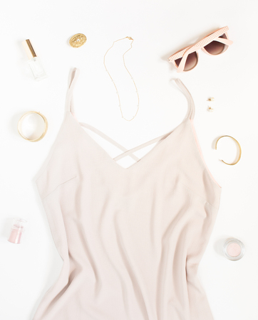 Beauty blog concept. Woman outfit. Pink dress, pink sunglasses, bracelets, necklace, earrings and cosmetics on white background. Trendy fashion feminine background. Fashion beauty background. Flat lay, top view.の写真素材