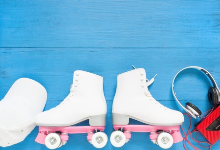Sport, healthy lifestyle, roller skating background. White roller skates, headphones and white baseball cap. Flat lay, top view.の写真素材