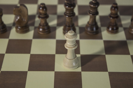 Queen facing enemies all alone in chess boardの写真素材